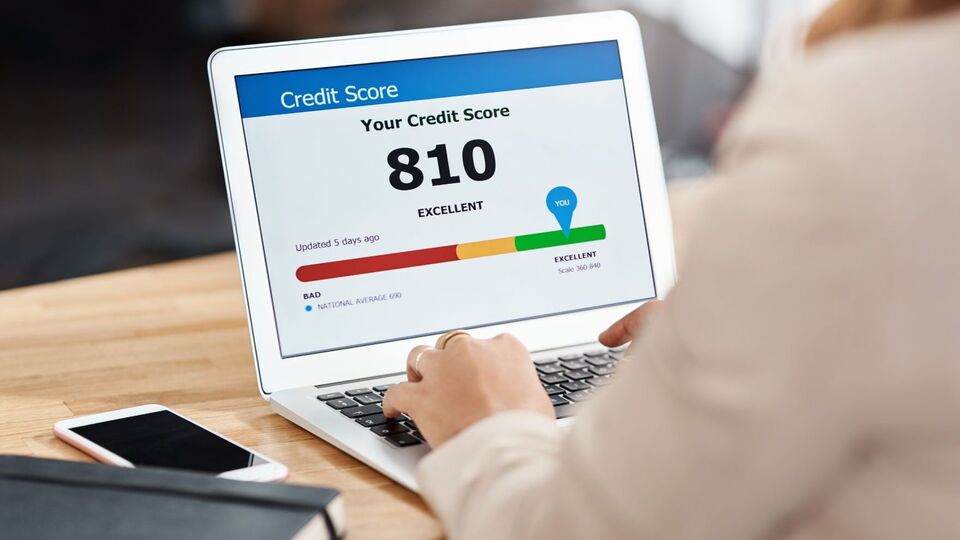 How emergency savings protect your CIBIL score showing excellent credit score on laptop